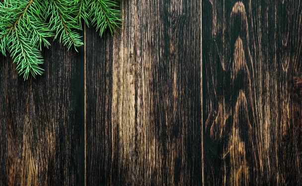 Spruce branches on a dark vintage wooden background. Christmas concept - Фото, изображение