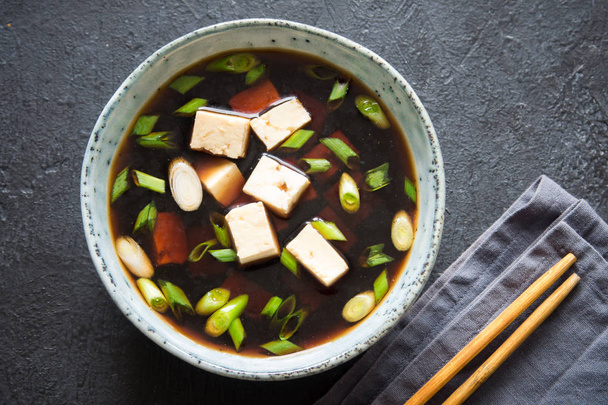 Japanese miso soup in ceramic bowl on dark background, copy space. Asian miso soup with tofu. - Fotoğraf, Görsel