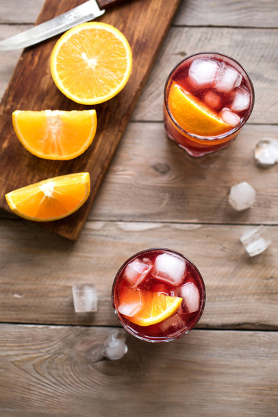 Negroni Cocktail with orange and ice. Homemade Classic Negroni cocktail and ingredients on wooden table, copy space. - Foto, imagen