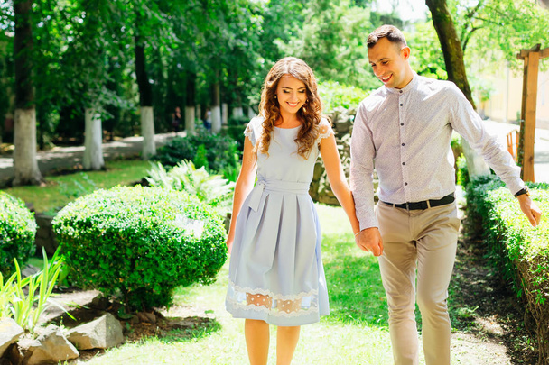 mec et fille en vêtements de fête se tiennent la main et marchent dans un beau parc par une belle journée ensoleillée
 - Photo, image