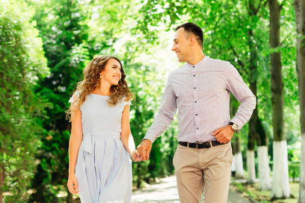 男と女が手を繋いでいると公園散策と率直に言って笑みを浮かべて - 写真・画像