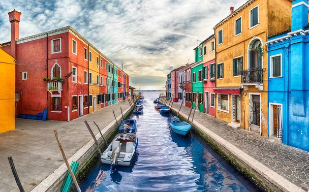 Colourful painted houses along the canal on the island of Burano, Venice, Italy. The island is a popular attraction for tourists due to its picturesque architecture - Photo, Image