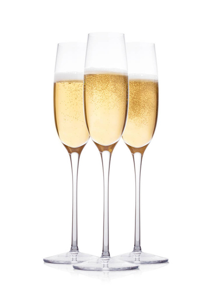Elegantes copas de champán amarillo con burbujas sobre fondo blanco con reflejo
 - Foto, imagen