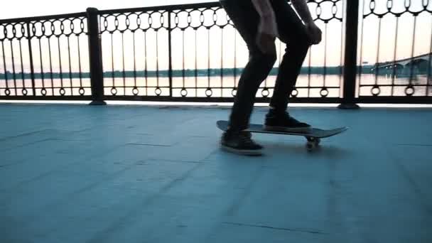 Hombre patina en un monopatín al atardecer, cámara lenta
 - Metraje, vídeo
