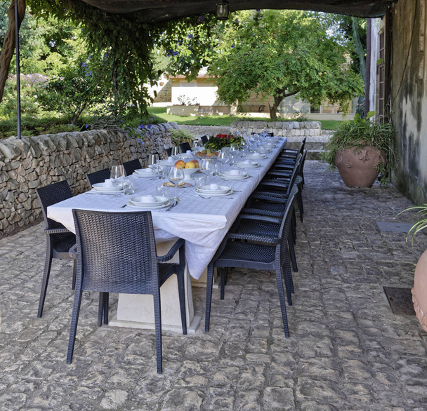 Italia, Sicilia, Mesa en el jardín de una casa de campo en el campo
 - Foto, Imagen