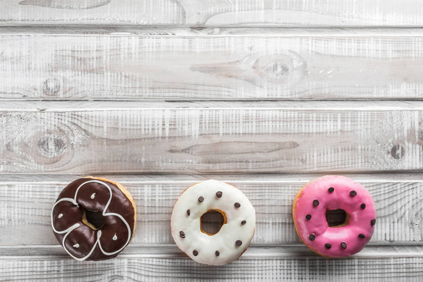Three donuts placed at the bottom of the table, top view, advertising space - Photo, Image
