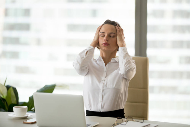 Стресована бізнес-леді має головний біль на роботі тримає голову в h
 - Фото, зображення
