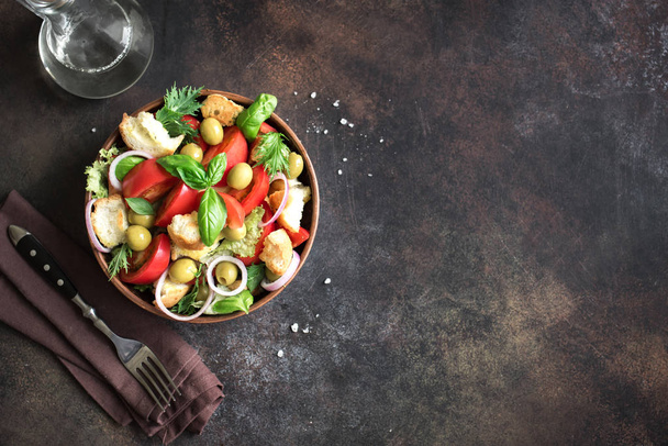 Panzanella Tomato Salad with cherry tomatoes, basil and ciabatta croutons. Summer healthy food - panzanella salad, top view, copy space. - Фото, изображение