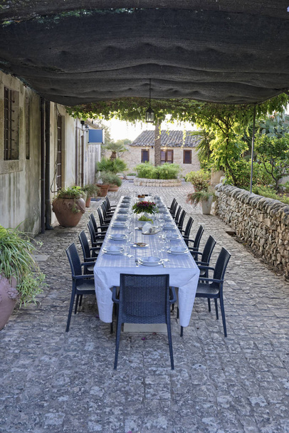 Italië, Sicilië, gedekte tafel in de tuin van een boerderij op het platteland - Foto, afbeelding