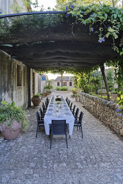 Italië, Sicilië, gedekte tafel in de tuin van een boerderij op het platteland - Foto, afbeelding