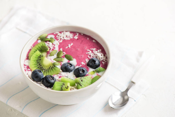 Smoothie bowl with fresh berries, fruits, seeds and coconut cream for healthy vegan vegetarian diet breakfast. Acai blueberry coconut smoothie bowl. - Zdjęcie, obraz