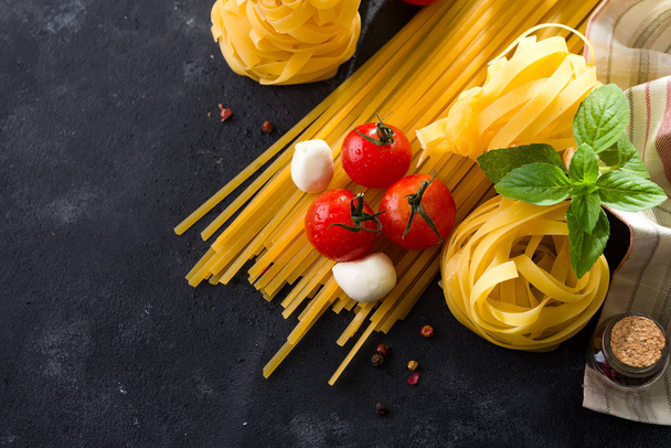 bovenaanzicht van ingrediënten voor het koken van pasta op leisteen oppervlak - Foto, afbeelding