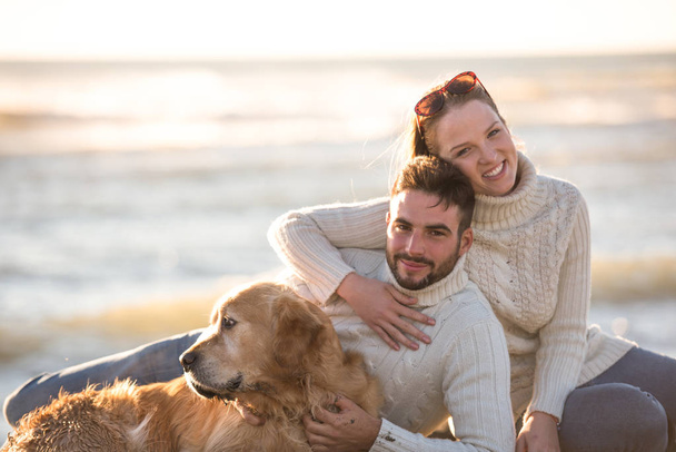 Couple With A Dog enjoying time  together On The Beach at autumn day - Photo, Image