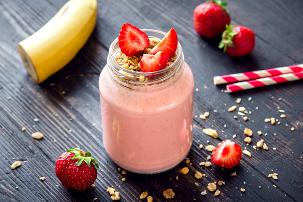 Strawberry and banana smoothie with homemade granola. Healthy breakfast or snack. Banana and strawberry smoothie in glass jar. - Фото, изображение