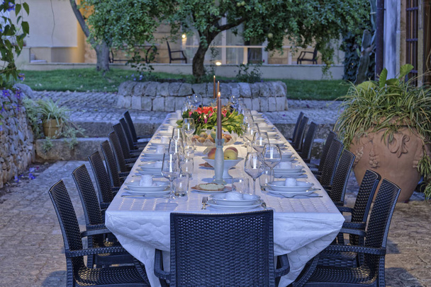 Ιταλία, Σικελία, στρωμένο τραπέζι στον κήπο του μια αγροικία στην ύπαιθρο - Φωτογραφία, εικόνα