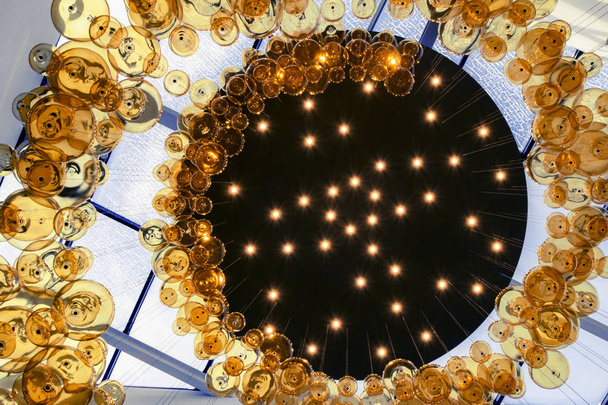 suspended glass balls in a spiral to a black circle with stars.  - Photo, Image