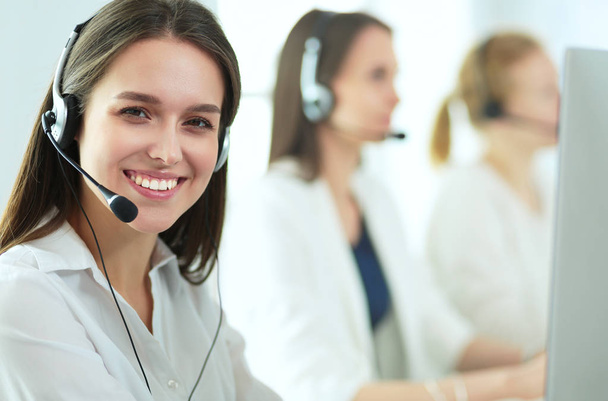 Smiling businesswoman or helpline operator with headset and computer at office - Фото, зображення