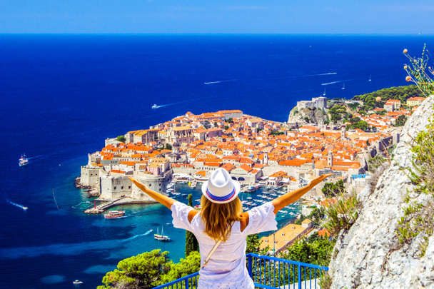 Happy νεαρό κορίτσι απολαμβάνει θέα προς την παλιά πόλη (μεσαιωνική Ραγκούζα) και Δαλματικές ακτές της Αδριατικής θάλασσας στο Ντουμπρόβνικ. Γαλάζιο με λευκό σκάφη, όμορφο τοπίο, αεροφωτογραφία, Ντουμπρόβνικ, Κροατία - Φωτογραφία, εικόνα