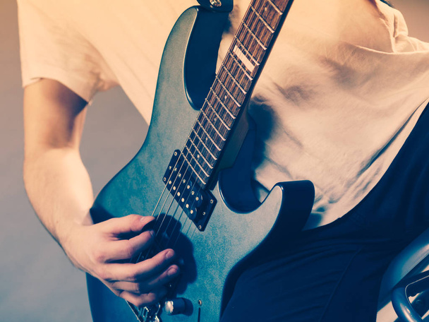 Close up of man playing on electric guitar during gig or at music studio. Musical instruments, passion and hobby concept. - Foto, Bild