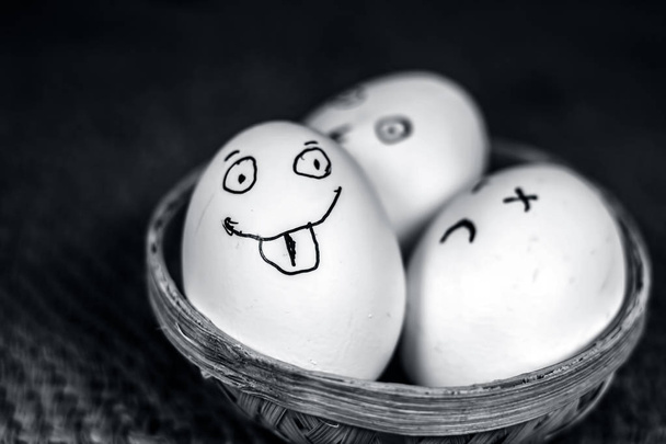 tojás, egy hagyományos kosárban vicces arcok  - Fotó, kép