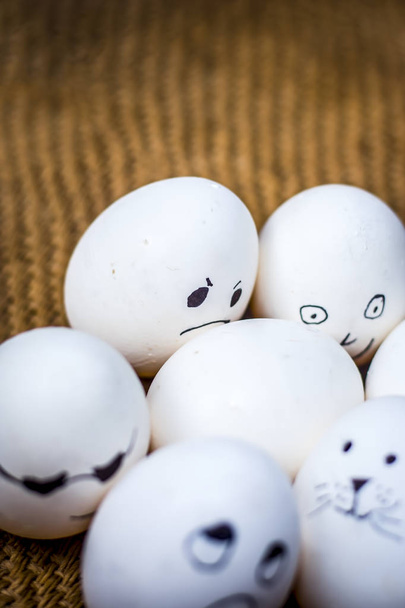 Close up view of eggs with funny faces drawn on them. - Photo, Image