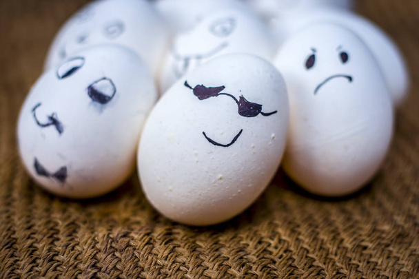 Close up view of eggs with funny faces drawn on them. - Foto, afbeelding