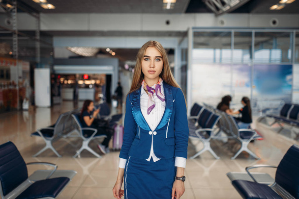 Lentoemäntä poseeraa lentokentän odotusalueella. Lentoemäntä lähtöalueella, lentoemäntä terminaalissa, lentokenttätyö
 - Valokuva, kuva