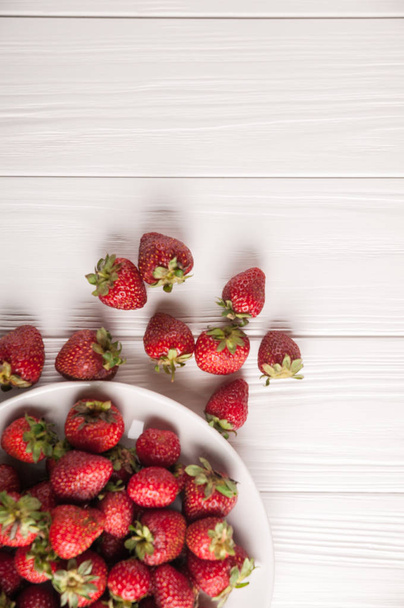 Čerstvé jahody v talíř na bílém pozadí dřevěná - Fotografie, Obrázek