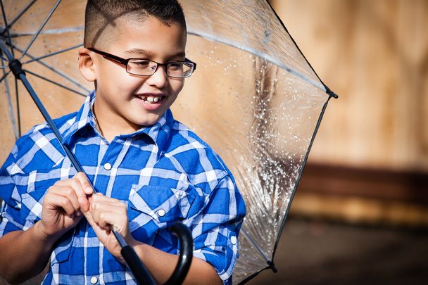 Smiling young boy in the rain with umbrella - Фото, зображення