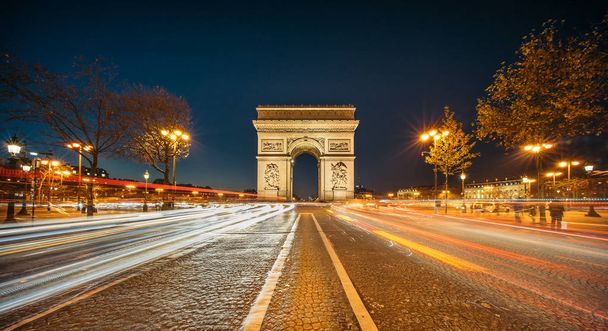 O Arco do Triunfo de l 'Etoile (Arco Triunfal da Estrela) à noite. É um dos monumentos mais famosos de Paris, de pé no extremo oeste do Champs-Elyseees
 - Foto, Imagem