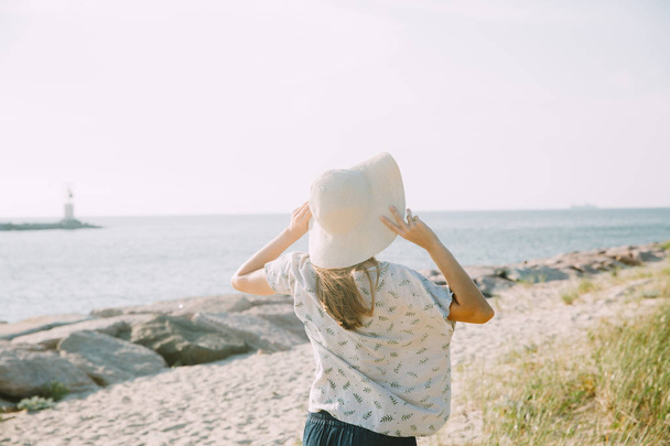 Young woman with straw hat near the seaside - Фото, зображення