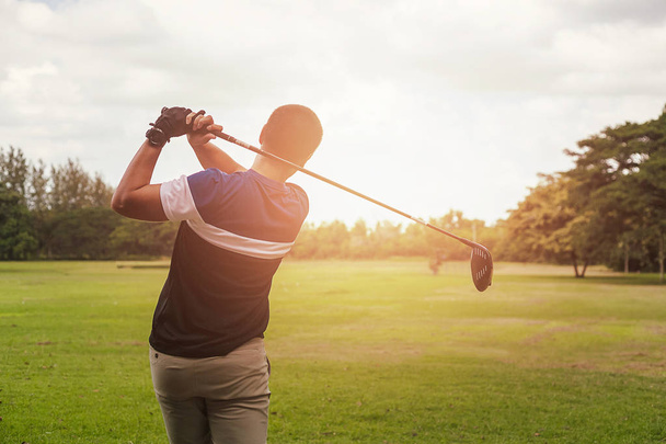 Golfer hitting golf shot with club on course at evening time. - Photo, Image