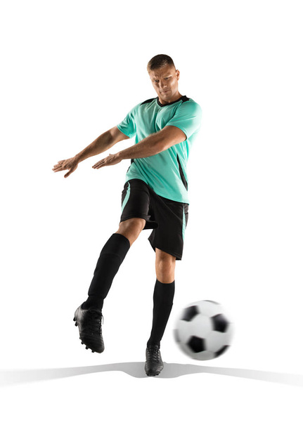 ποδοσφαιριστής που κλωτσάει την μπάλα στο απομονωθεί σε λευκό - Φωτογραφία, εικόνα