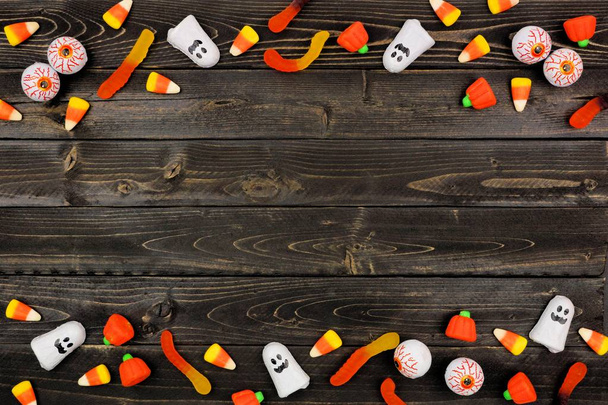 Halloween-Bonbons doppelte Umrandung über dunklem schwarzem Holz. Kopierraum. - Foto, Bild