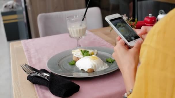 Mujer tomando la foto de la ensalada sabrosa con teléfono celular en el restaurante
 - Imágenes, Vídeo