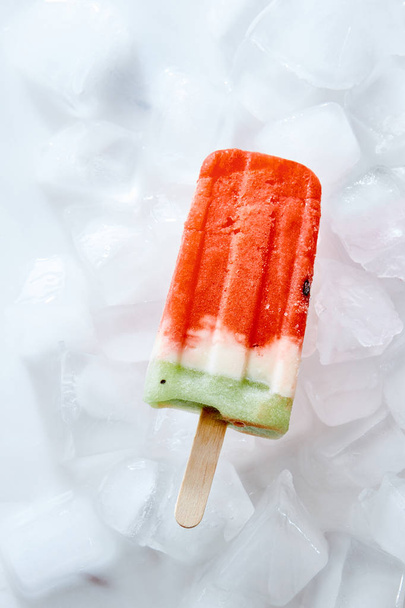 Frozen natural vanilla watermelon smoothies on a stick on ice cubes. Ice lolly. Top view - Foto, immagini