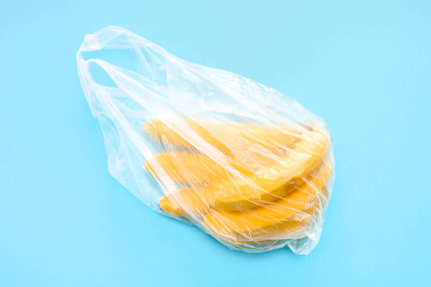 Yellow ripe fresh bananas in transparent plastic bag - Foto, imagen