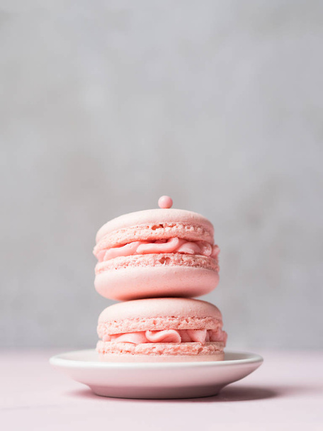 Couple fresh strawberry macaroons on saucer over stone grey background - Foto, immagini