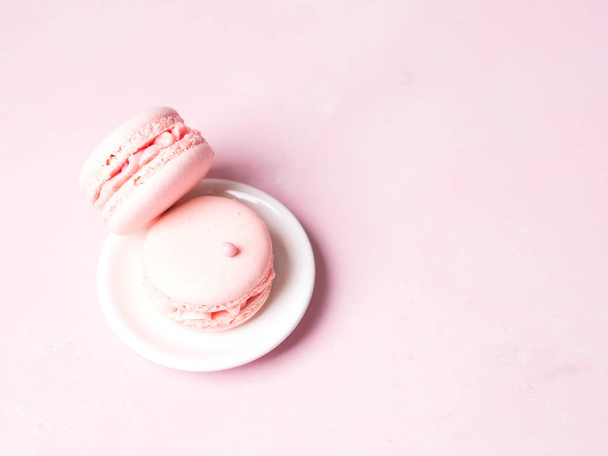 French strawberry macaroons on saucer over pink pastel background - Foto, immagini