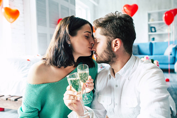 Young man and woman drinking champagne at bedroom - Фото, зображення