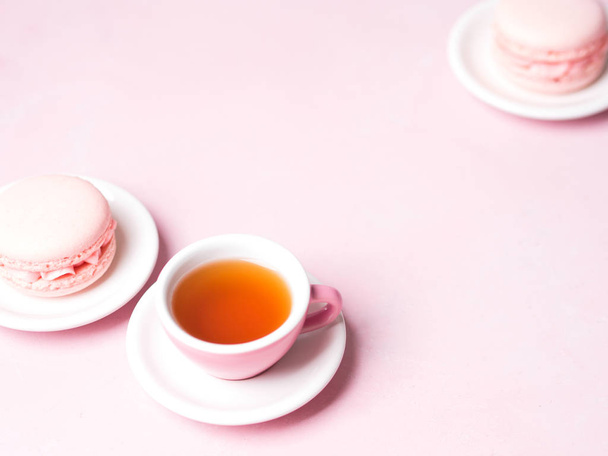cup of tea served with fresh strawberry macaroons on pink pastel background - Foto, Bild