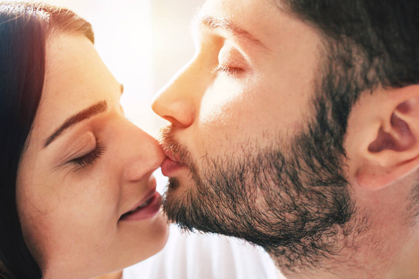 Young couple kissing, focus on foreground - Valokuva, kuva