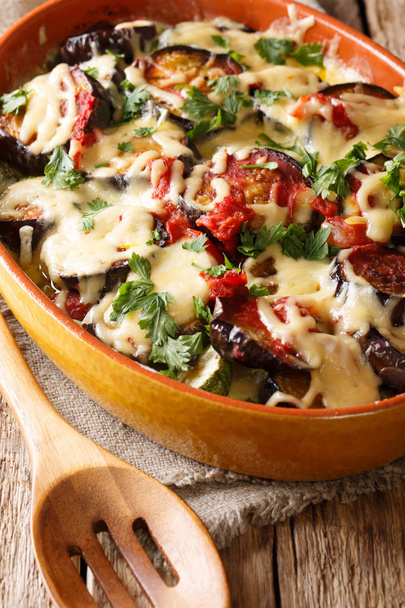 Caçarola vegetal de berinjelas com tomate e queijo mussarela e parmesão close-up em um prato para assar. vertica
 - Foto, Imagem