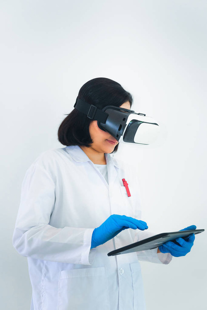 Portret van vrouw wetenschapper is met behulp van Tablet PC tijdens een vr bril in laboratorium kamer. - Foto, afbeelding