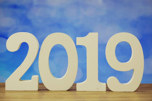 2019 happy new year with number letters on blue bokeh background - Foto, afbeelding