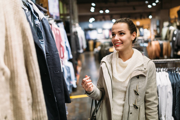 Mujer atractiva joven comprando ropa en el centro comercial
 - Foto, Imagen