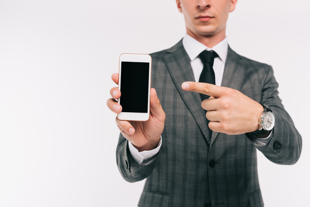 cropped image of businessman pointing on smartphone with blank screen isolated on white - 写真・画像