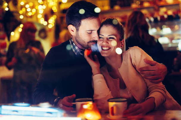 Romantic young couple dating in pub at night - Fotoğraf, Görsel