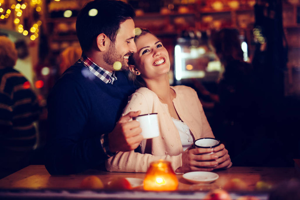 Romantic young couple dating in pub at night - Фото, изображение