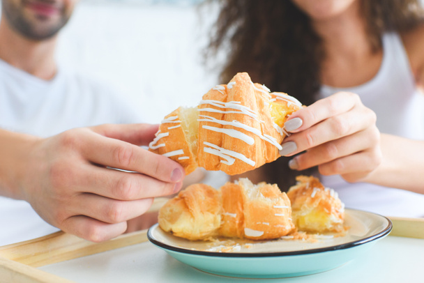 close-up view of young couple sharing croissant for breakfast - Fotografie, Obrázek